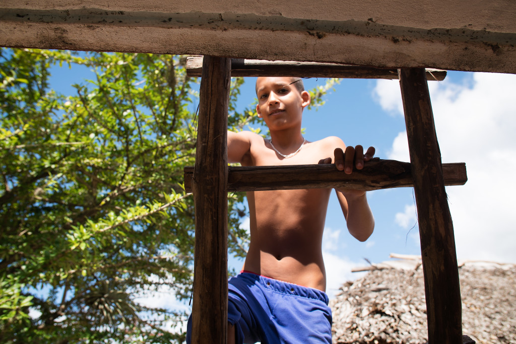 A young boy climbs the ladder to the roof of his family home on the road to Baracoa in Eastern Cuba. Photographed on a Tamron 24-70 f/28 at 1/640 at f/3.2. 