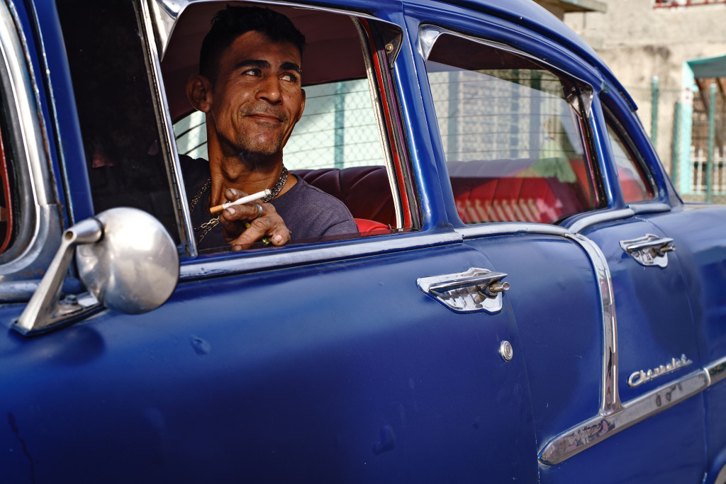 Alex smokes a cigarette as he talks to his neighbor before leaving to work as a taxi driver in Holguin. Photographed with a Tamron 24-70 f/2.8 at 1/200 and f/5.6.
