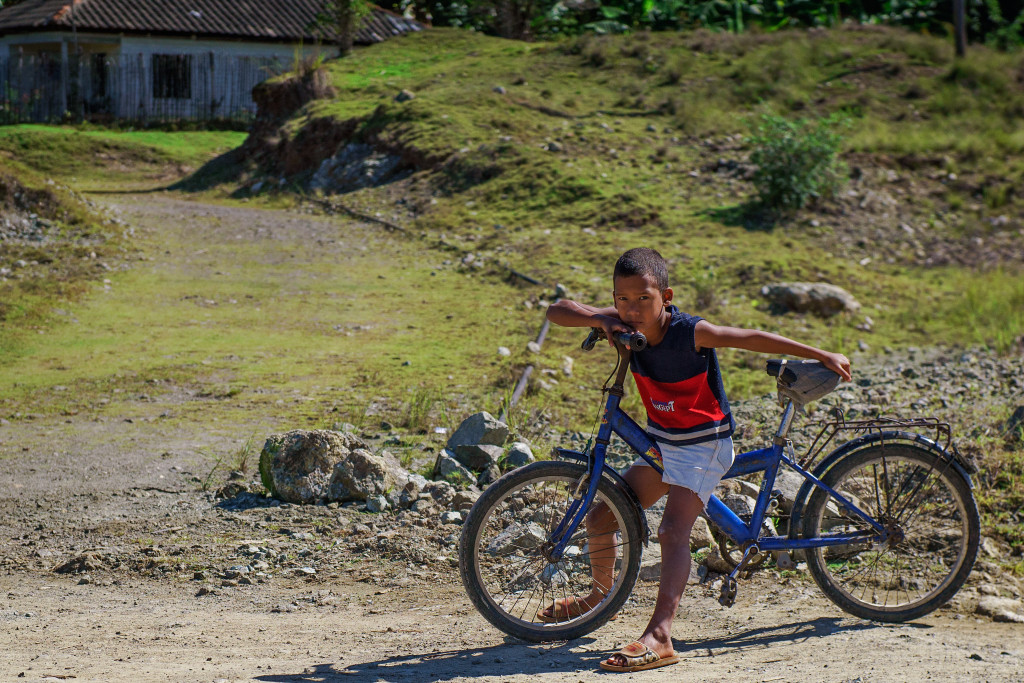 A boy rests on his bike on the road between Baracoa and Moa. Photographed with a Tamron 24-70mm f/2.8 at 1/6400 and f/2.8.