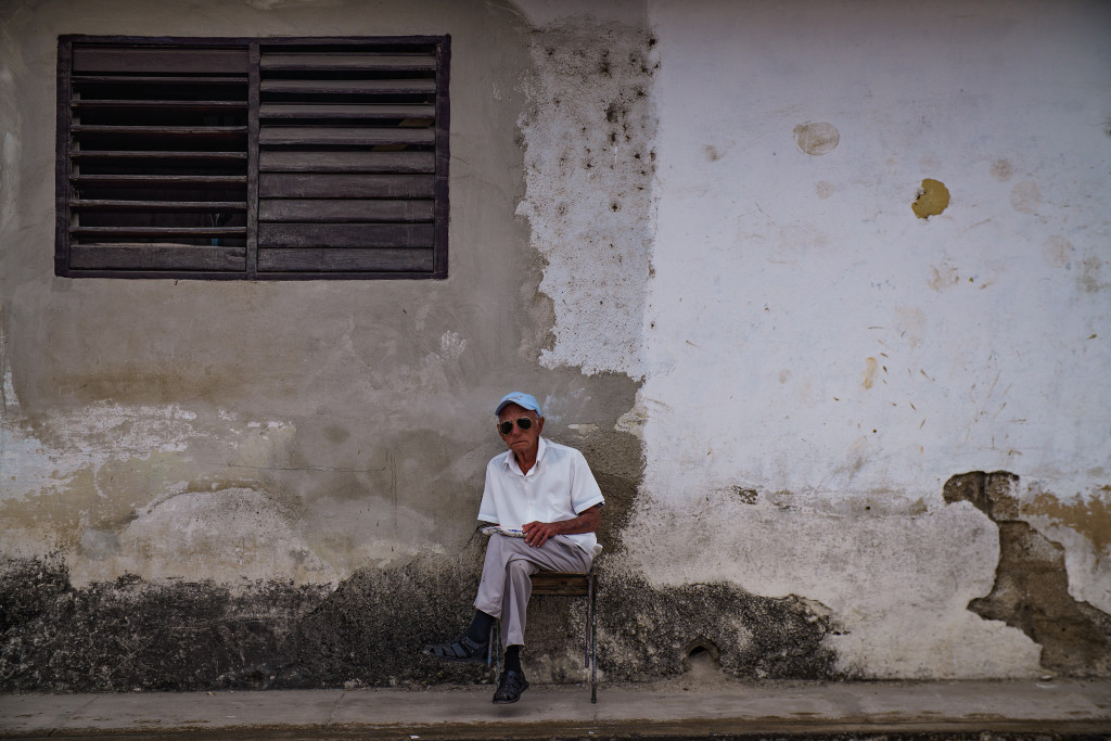 A man rocks back in his chair while waiting for the day to pass by in Holguin. Photographed with a Tamron 24-70 f/2.8 at 1/640 and f/2.8.
