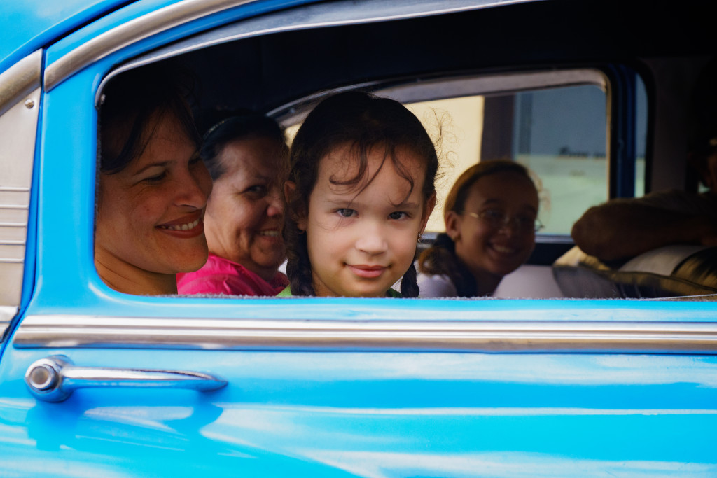 A girl peers out of her family vehicle in Holguin. Photographed with a Tamron 24-70 f/2.8 at 1/1250 and f/4.5.