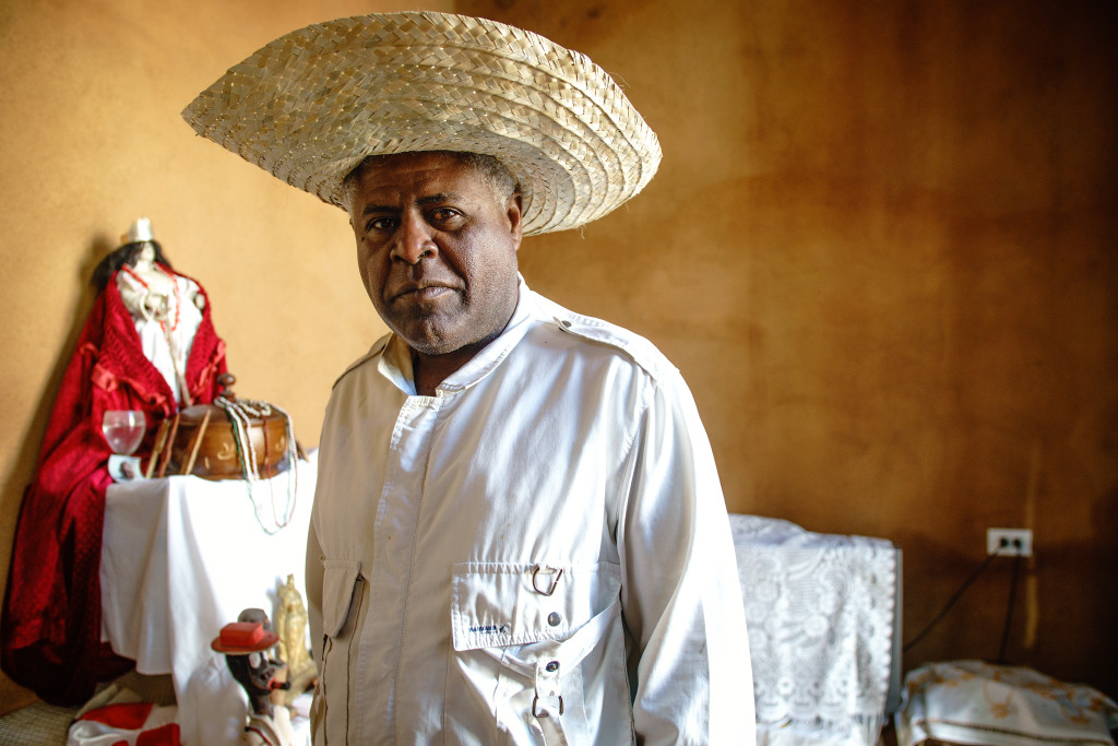 The local Santaria priest in Trinidad poses in front of his alter, located in the entry way of his home. Photographed on a Tamron 24-70mm, 1/125 seconds, f/2.8.